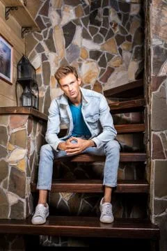 Young handsome man model against natural stone background. Stock Photos