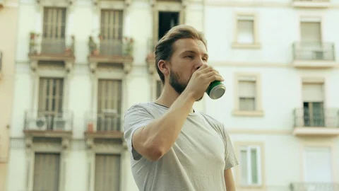 Young Handsome Man Opens a Can of Beverage and Drinks Stock Footage 129349971