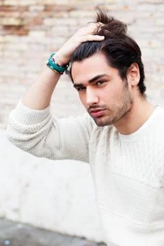 Young handsome man passing his hand through his hair. Trendy hair and stubble Stock Photos