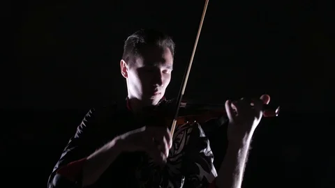 Young handsome man plays electric violin on black background, isolated Vídeo Stock 107871525