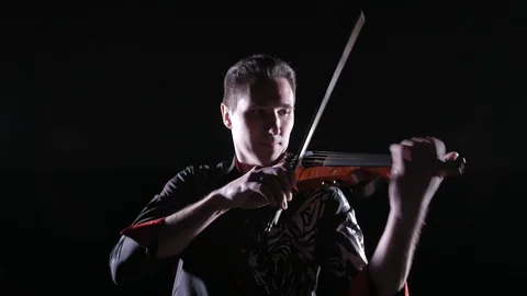 Young handsome man plays electric violin on black background, isolated Stock-Footage 107871541