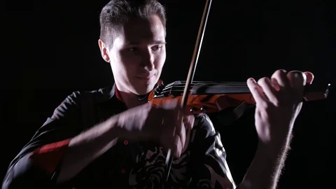 Young handsome man plays electric violin on black background, isolated Stock-Footage 107871542