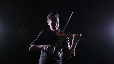 Young handsome man plays electric violin on black background, isolated Vídeos de archivo 107871553