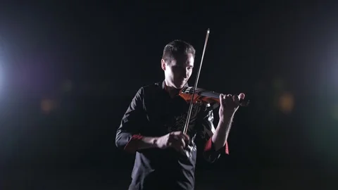 Young handsome man plays electric violin on black background, isolated 库存影片 107871557