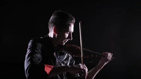 Young handsome man plays electric violin on black background, isolated Stock-Footage 107871567
