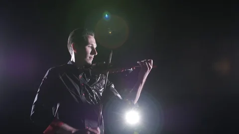 Young handsome man plays electric violin on black background, isolated Stock-Footage 107871593