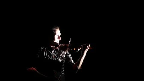 Young handsome man plays electric violin on black background, isolated Stock-Footage 107871719