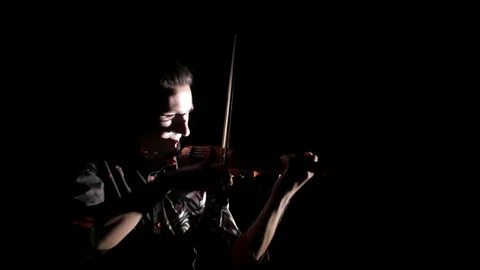 Young handsome man plays electric violin on black background, isolated 库存影片 107871736