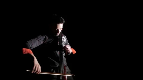 Young handsome man plays electric cello on black background, isolated Stock-Footage 107871807