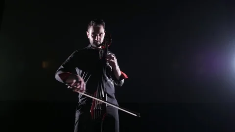 Young handsome man plays electric cello on black background, isolated 库存影片 107871945