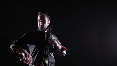 Young handsome man plays electric cello on black background, isolated Stock-Footage 107871958