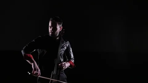 Young handsome man plays electric cello on black background, isolated 스톡 동영상 107872048