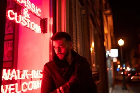 Young handsome man posing close to neon lights in the street Foto stock