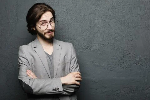 Young handsome man posing on gray wall background Stock Photos