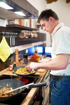 Young handsome man preparing dinner Stock Photos
