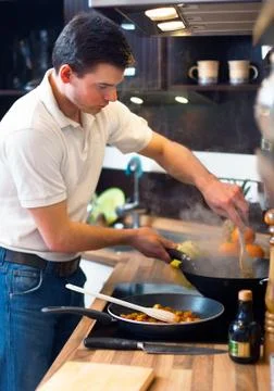 Young handsome man preparing lunch Stock Photos