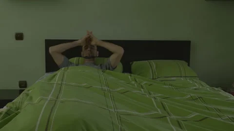 Young handsome man pulling the blanket and sleeping Stock Footage 59841938