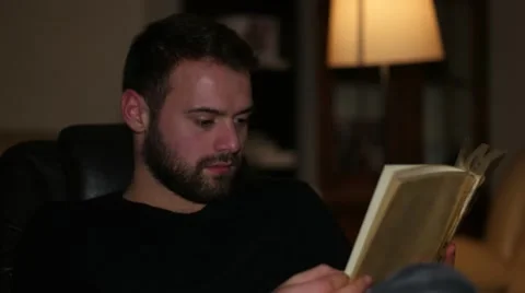 Young handsome man reading book at home Vídeo Stock 59955627