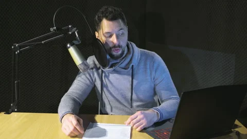 Young handsome man reading text from laptop in a recording studio. Stock Footage 169251485