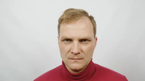 Young handsome man in red sweater posing for the camera.restrains anger Stock Footage 103886256