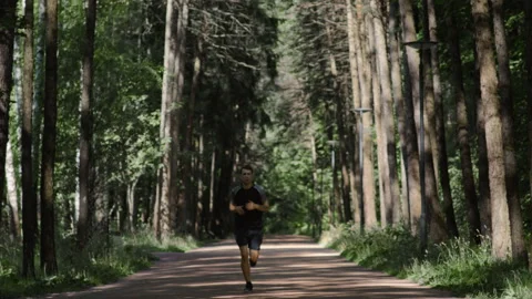 Young handsome man running marathon in city park Stock Footage 201135496