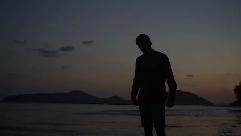 Young handsome man silhouette on the beach sunset. Stock Footage 107444908