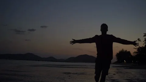 Young handsome man silhouette on the sunset celebrating success. Stock Footage 107444963