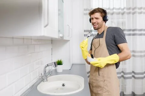 Young Handsome Man Singing While Washing Dishes Stock Photos