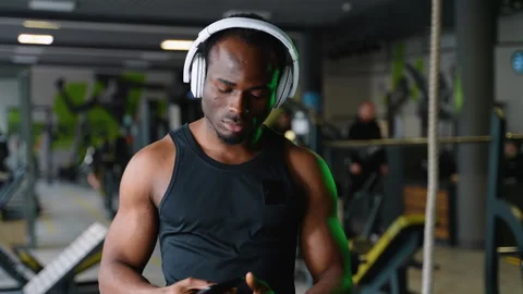 Young handsome man in sportswear using his smartphone and listens to music while Stock Footage 270098543