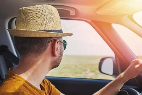 Young handsome man in straw hat driving car Stock Photos