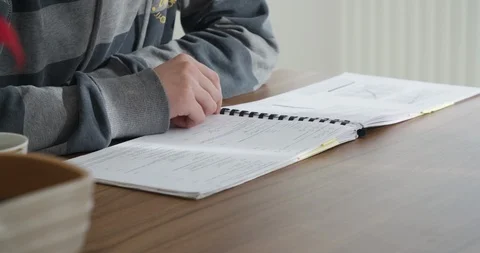 Young handsome man, student studying in his home, checking and reading notes.  Stock Footage 124101866