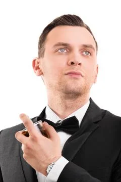 Young handsome man in a suit using a perfume Stock Photos