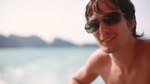 Young handsome man in sunglasses sitting on yacht sailing on his vacation Video stock 87906643