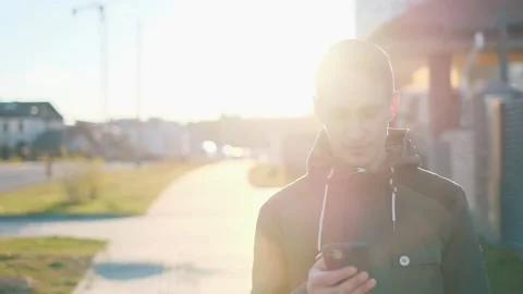 Young handsome man is tapping mobile phone with sunlight. Stock Footage 132737084