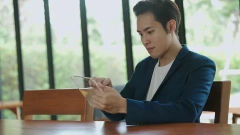 Young handsome man touching  invisible hologram virtual screen on tablet Stock Footage 147372370