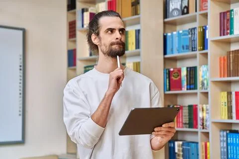 Young handsome man using digital tablet inside library office Stock Photos