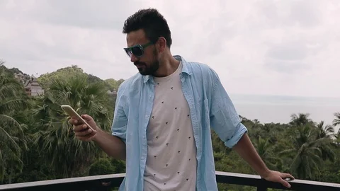 Young handsome man using his smartphone at the vacation. Stock Footage 100955811