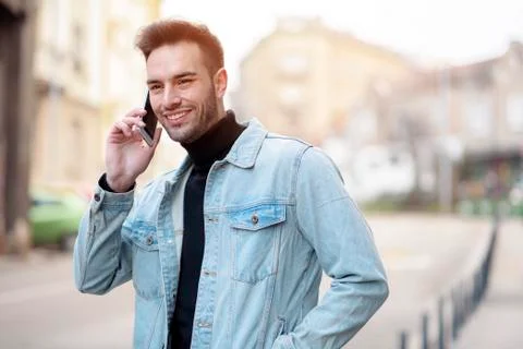 Young handsome man using his cell phone, enjoying a day on the street Stock Photos