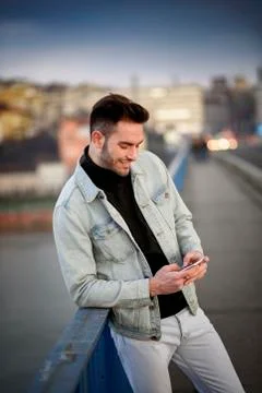 Young handsome man using his cell phone, enjoying a day on the street Stock Photos
