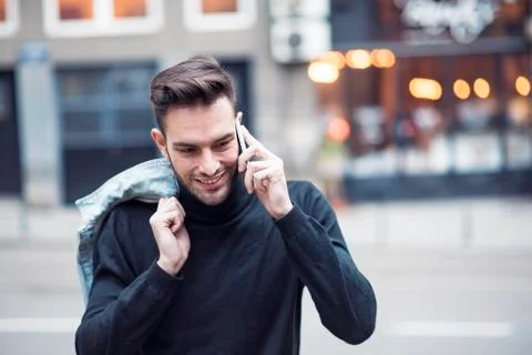 Young handsome man using his cell phone, enjoying a day on the street Stock Photos