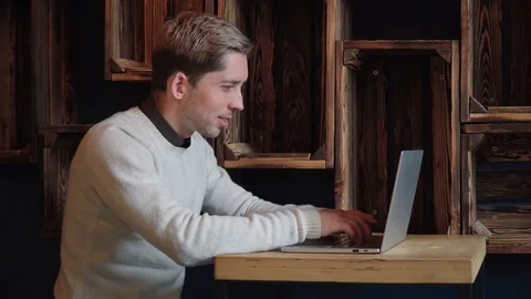 Young handsome man using laptop in cafe Stock Footage 75650286