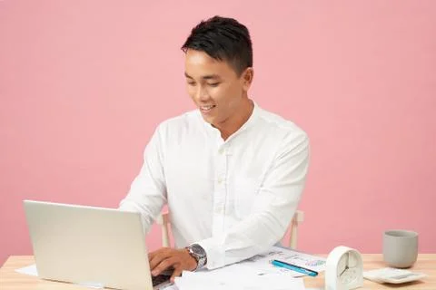 Young handsome man using laptop in his office.Asian Stock Photos