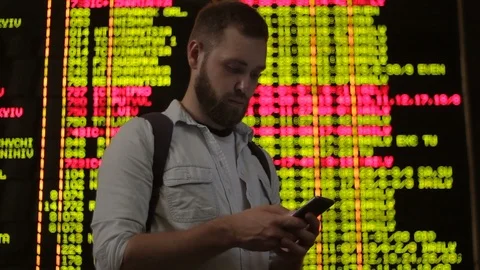 Young handsome man using mobile phone searching information about delayed flight Stock Footage 94234899
