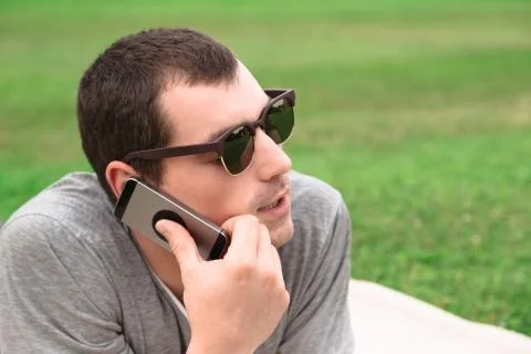 Young handsome man using mobile phone in park Stock Photos