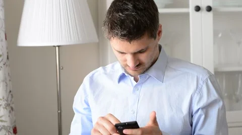 Young handsome man using smart phone in his flat. Stock Footage 53746885