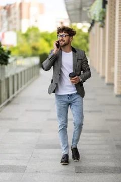 Young handsome man using smart phone with cup of coffee. Stock Photos