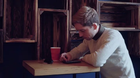 Young handsome man using smartphone in cafe Stock Footage 75650967