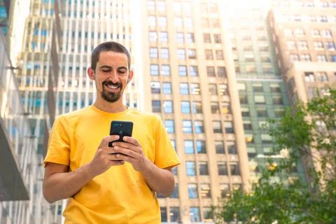 Young handsome man using smartphone in a city. Stock Photos
