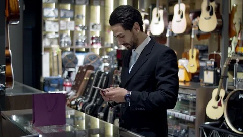 Young handsome man using smartwatch to express pay on counter Stock Footage 120436298
