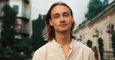 Young handsome man walking looking sideways straightens his hair and smiling. Stock Footage 127069017